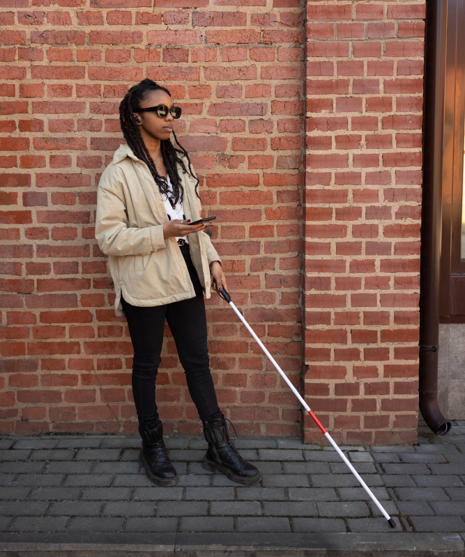 Picture of a woman with glasses and a white cane 